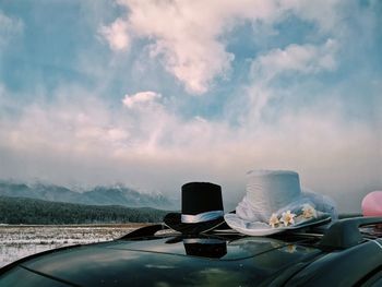 Cars on glass of car against sky