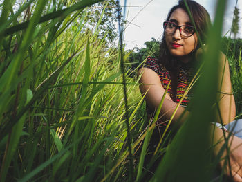 Beautiful young woman standing by grass