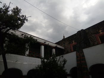 Low angle view of trees and buildings against sky