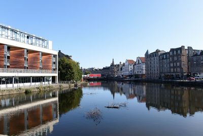 Reflection of buildings on river against sky