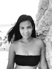 Portrait of young woman standing at beach