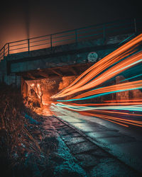 Light trails on road against sky at night