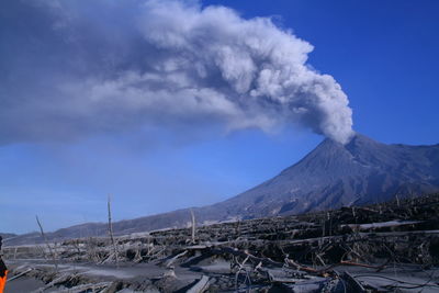 Smoke emitting from volcanic mountain against sky