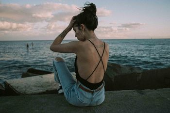 Rear view of woman sitting at beach