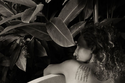 Rear view of sensuous woman by plants