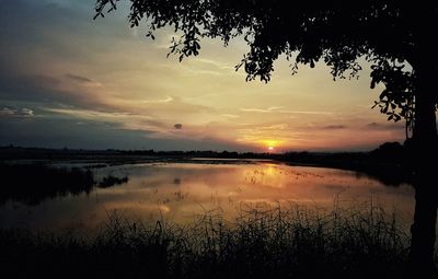 Scenic view of lake against sky at sunset