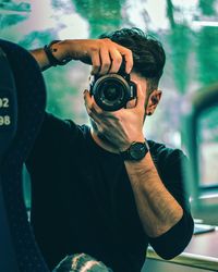 Portrait of young man photographing camera