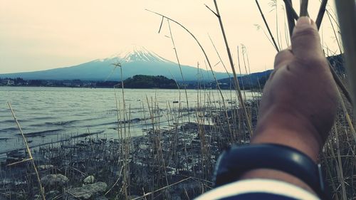 Midsection of man in sea against clear sky