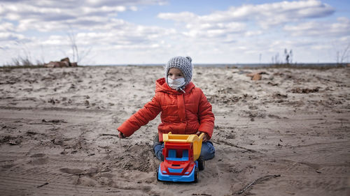 Portrait of girl with toy on land