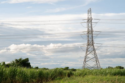 Electricity pylon on field against sky