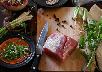 High angle view of meat with ingredients on cutting board in kitchen