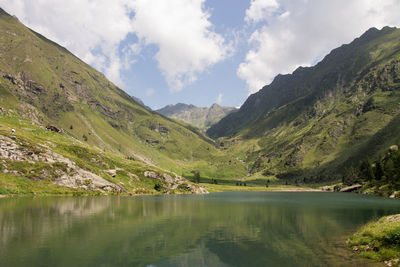 Scenic view of lake by mountains against sky