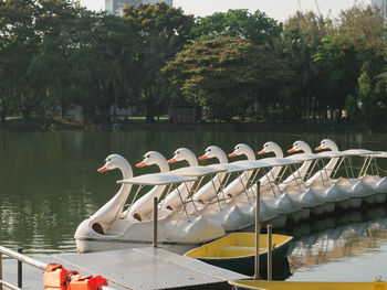 Boats moored in lake against trees