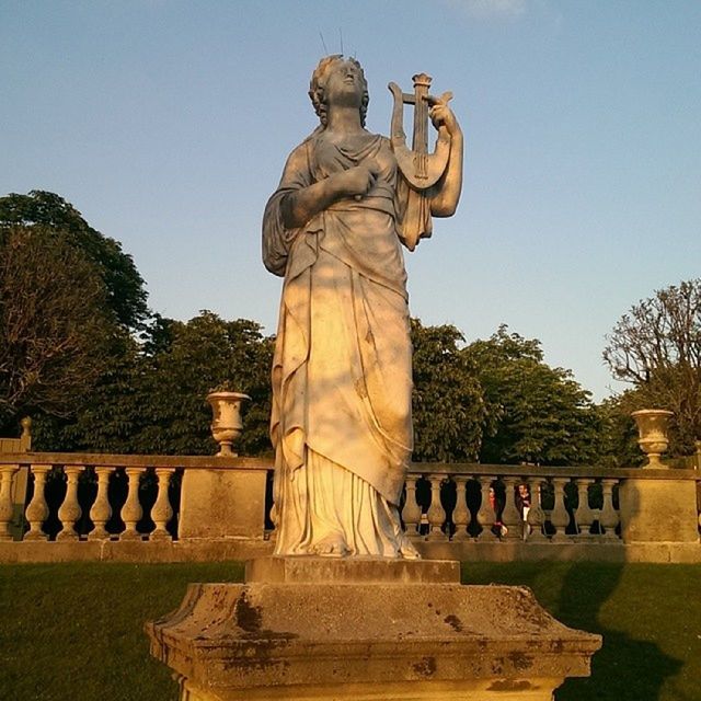 statue, sculpture, human representation, art and craft, art, creativity, tree, clear sky, monument, park - man made space, carving - craft product, craft, memorial, famous place, travel destinations, religion, sunlight, low angle view