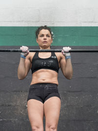 Low angle view of woman exercising against wall