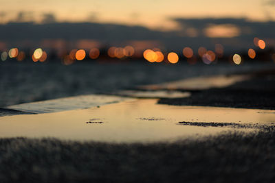 Surface level of beach against sky during sunset