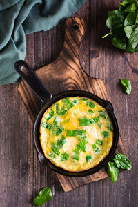 Omelet stuffed with spinach in a pan for breakfast on the table. homemade food. top and vertical 