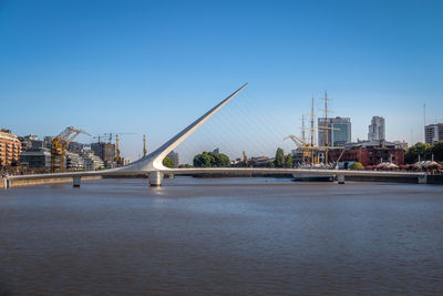 Bridge over river against clear blue sky