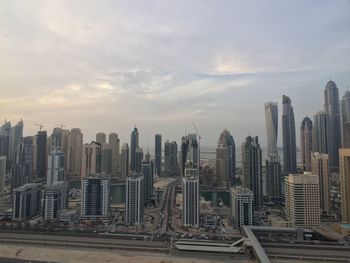 View of cityscape against cloudy sky
