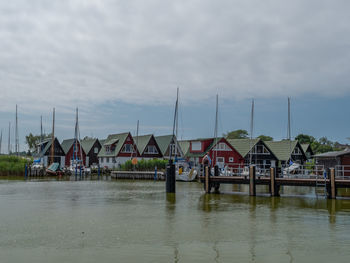 Houses by river against sky