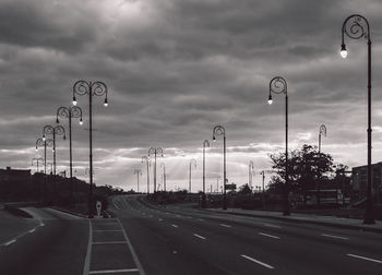 Cars on road against cloudy sky