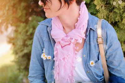 Midsection of woman standing against plants