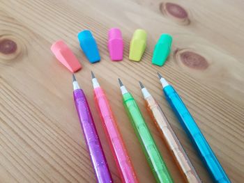 High angle view of multi colored pencils and erasers on table