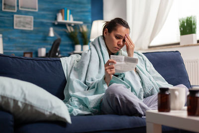 Full length of man sitting on sofa