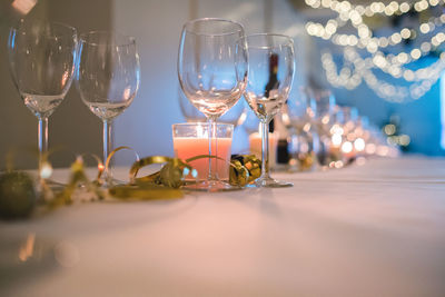 Wineglasses and tea light candles on table in party