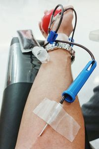 Close-up of needle in hand donating blood