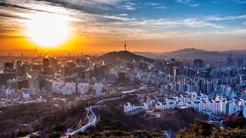 Aerial view of buildings in city during sunset