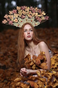 Portrait of a beautiful young woman with autumn leaves