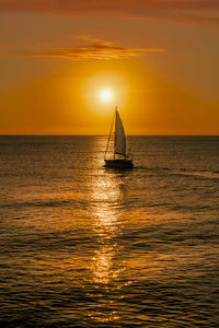 Scenic view of sea aand boat against sky during sunrise