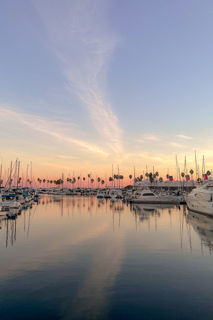 water, sky, reflection, nautical vessel, transportation, sunset, dock, nature, dawn, marina, sea, mode of transportation, ship, beauty in nature, harbor, cloud, architecture, horizon, evening, tranquility, vehicle, scenics - nature, no people, city, waterfront, moored, travel destinations, tranquil scene, pier, outdoors, travel, boat, built structure, twilight, building exterior, idyllic, landscape, sunlight, bay, blue, sun, building, watercraft