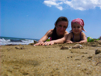 Friends on beach against sky