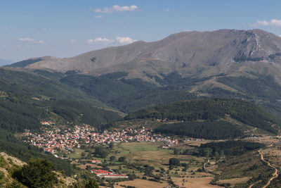 Aerial view of village and mountains against sky