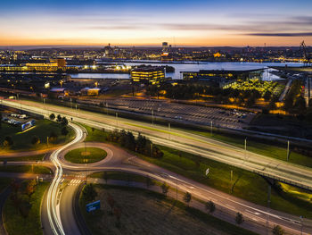 High angle view of illuminated cityscape against sky during sunset