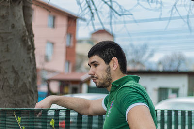 Portrait of young man looking away outdoors