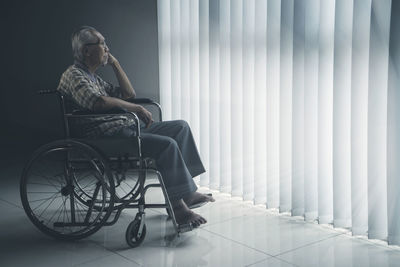 Side view of senior man sitting on wheelchair