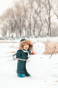 Side view of boy standing on snow