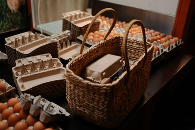 Close-up of wicker basket on market stall table in front of eggs