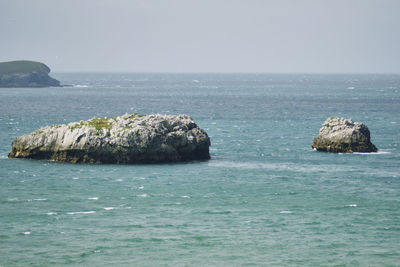 Scenic view of rocks in sea against sky