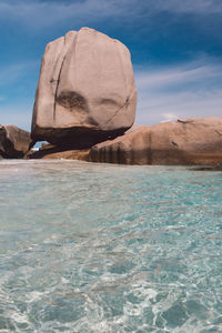Rock formation in sea against sky