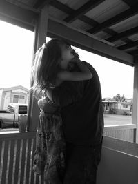 Father embracing daughter while standing in balcony