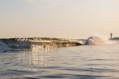 Water splashing in sea against clear sky