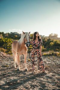 The girl relaxes with the white horse in the nature park