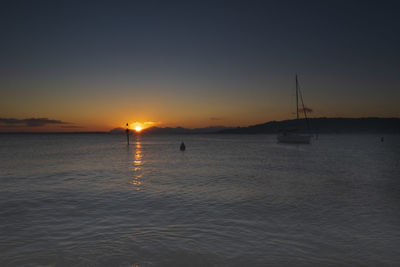 Silhouette sailboats in sea against sky during sunset