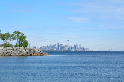 View of buildings by sea against sky