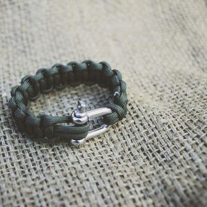 Close-up of green parachute cord bracelet on jute
