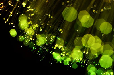 Defocused image of illuminated lights against black background